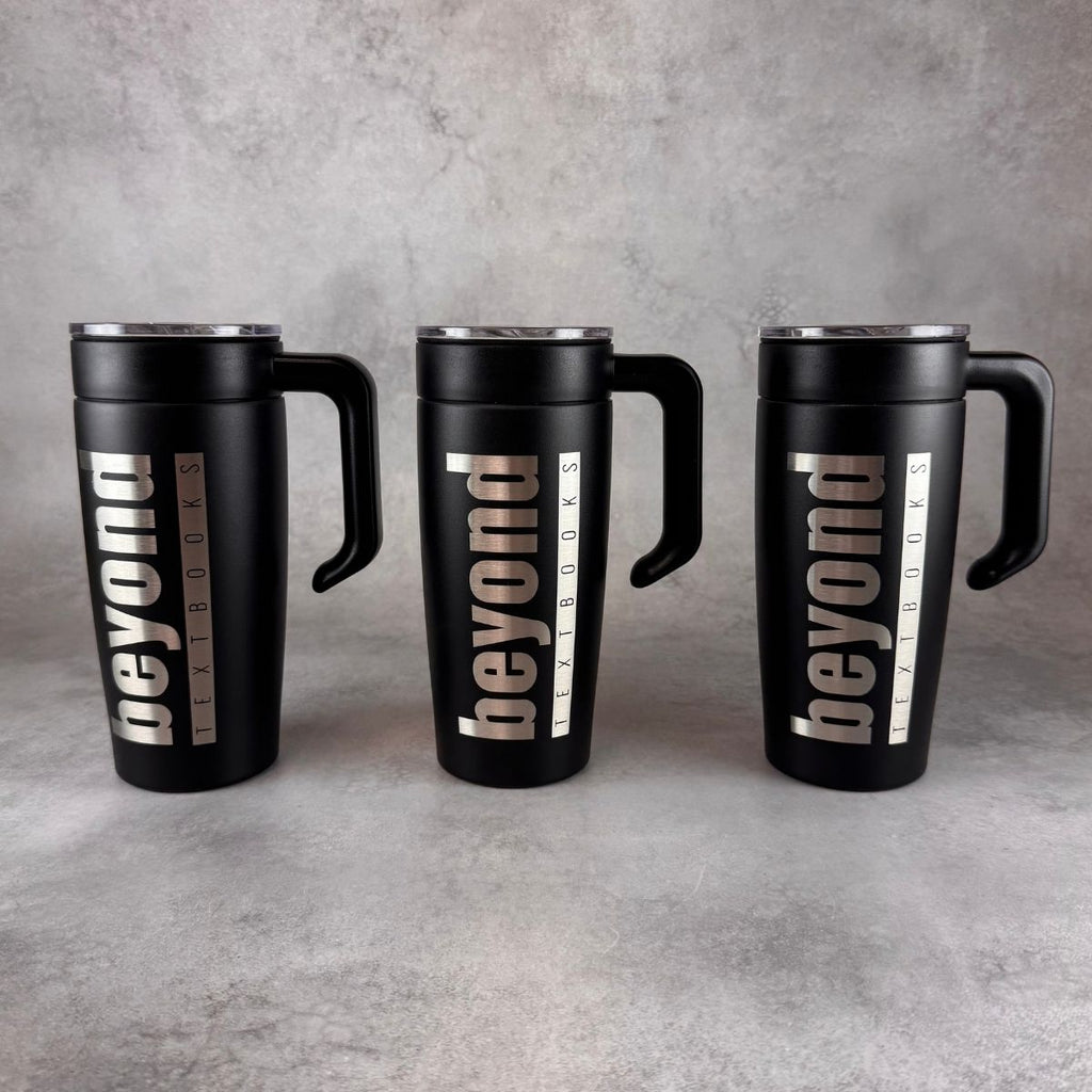 Three black insulated travel mugs with handles and lids, each engraved vertically with the word 'beyond' and smaller text reading 'textbooks', arranged side by side on a gray textured surface.