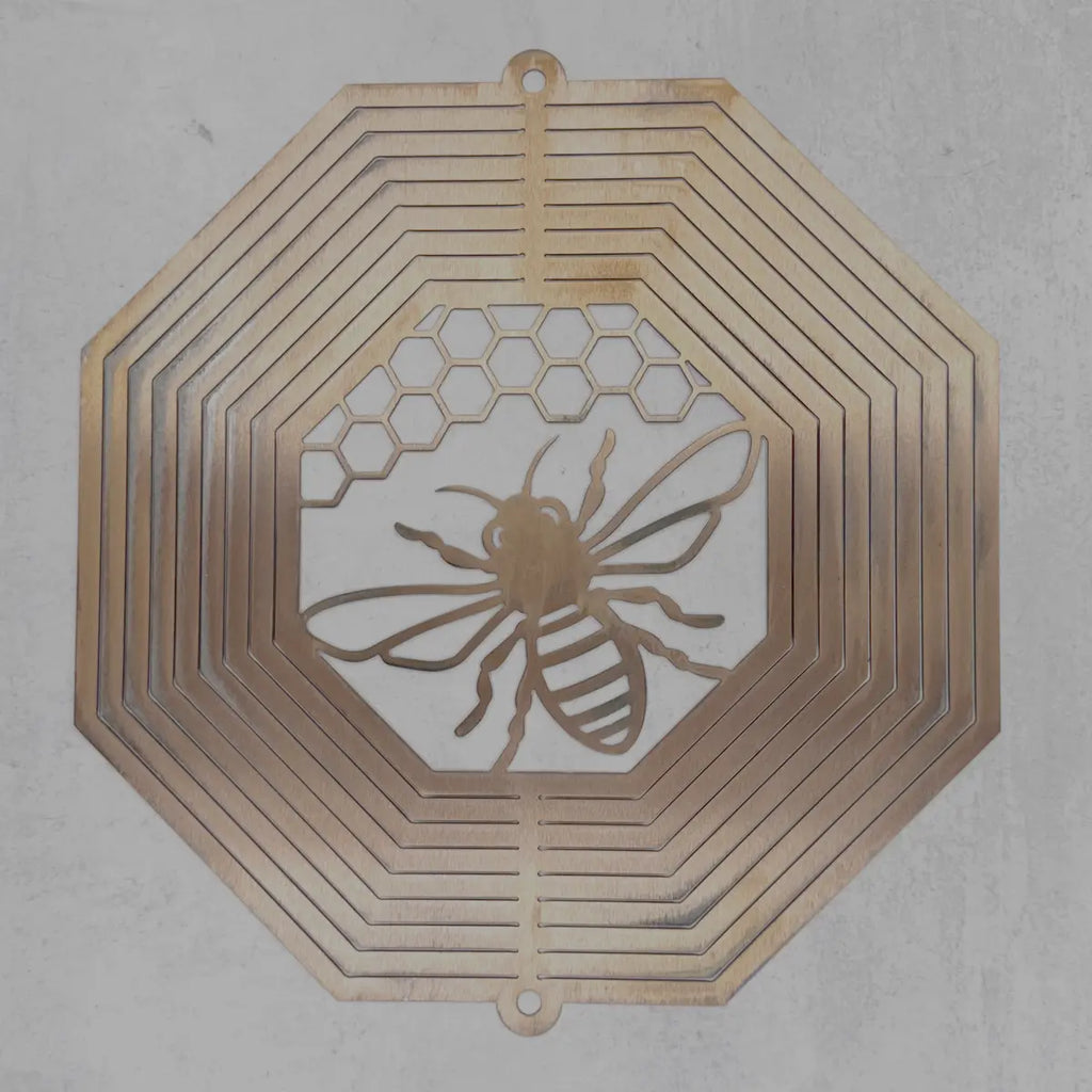 A laser-cut metal wall art piece featuring a bee and honeycomb pattern, displayed against a textured gray wall.