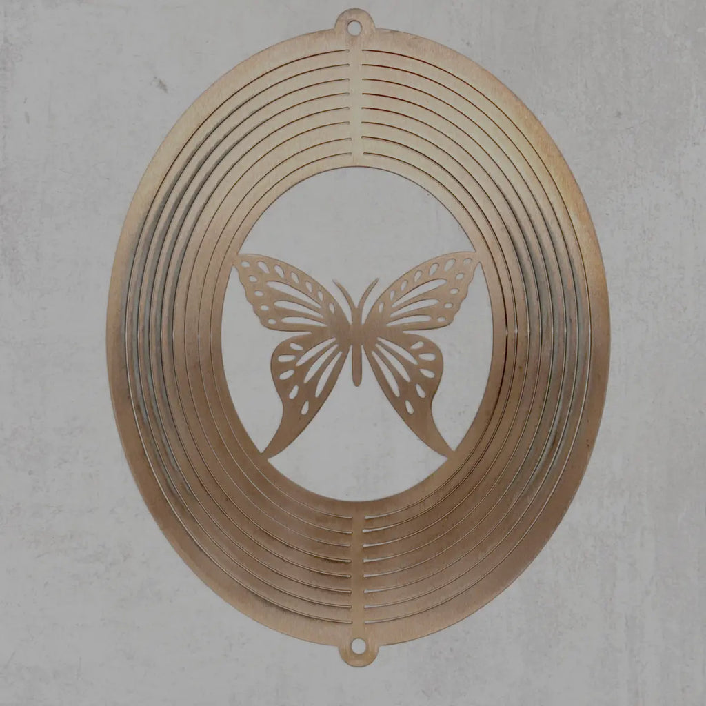 A circular metal wall art piece with a butterfly cutout in the center and concentric ring patterns around the border, shown against a textured light gray wall.