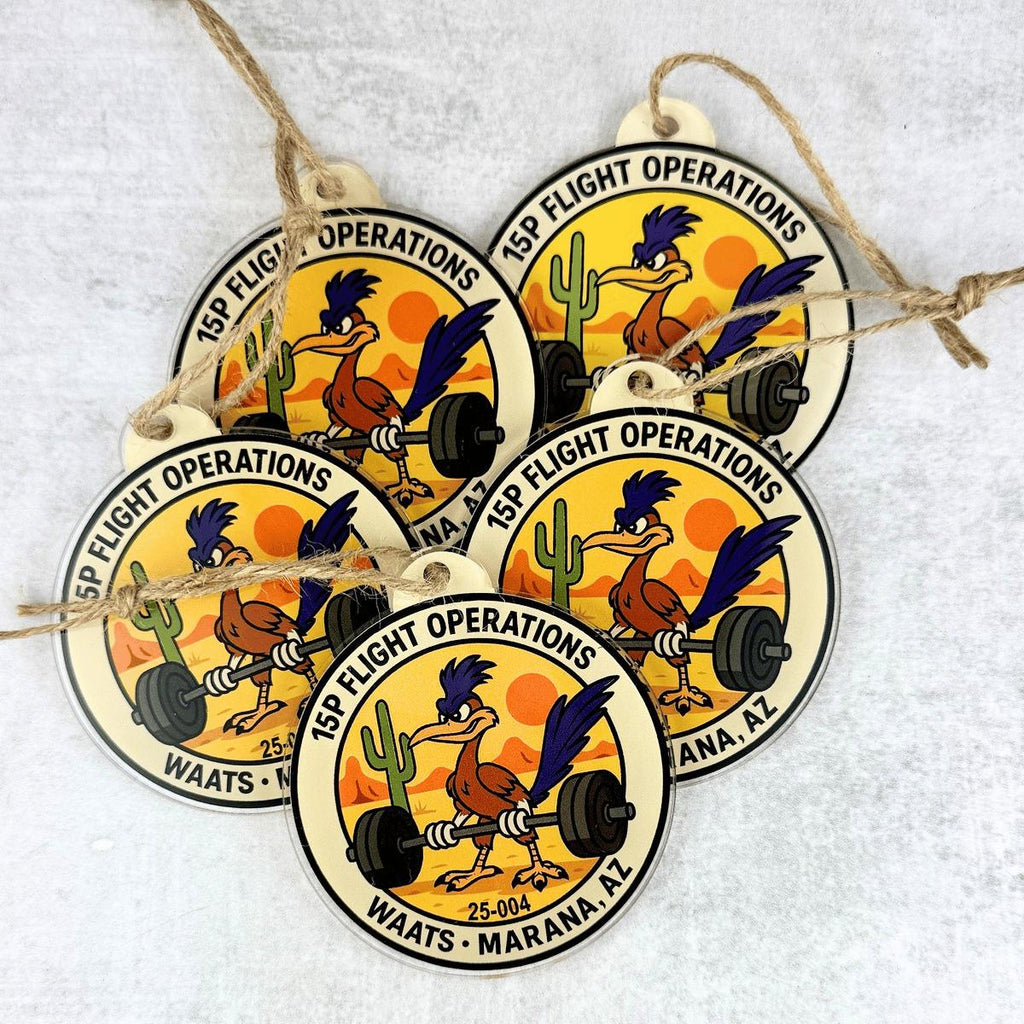 Five round hanging ornaments with twine loops, featuring a cartoon rooster lifting a barbell and the text '15th Flight Operations' and 'Waats - Marana, AZ' on a light textured background.