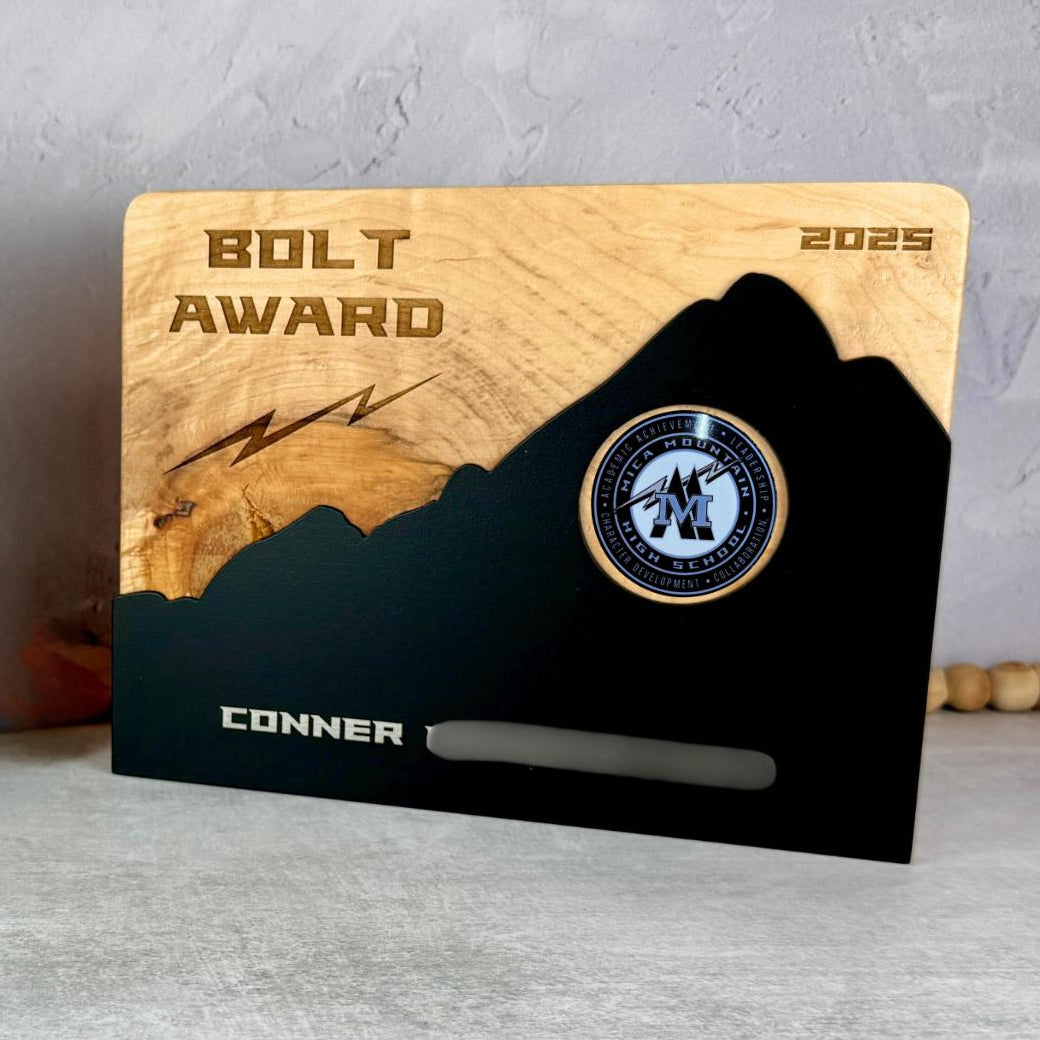 Plaque with hardwood back with rounded corners and metal plate in the shape of a mountain in front. 