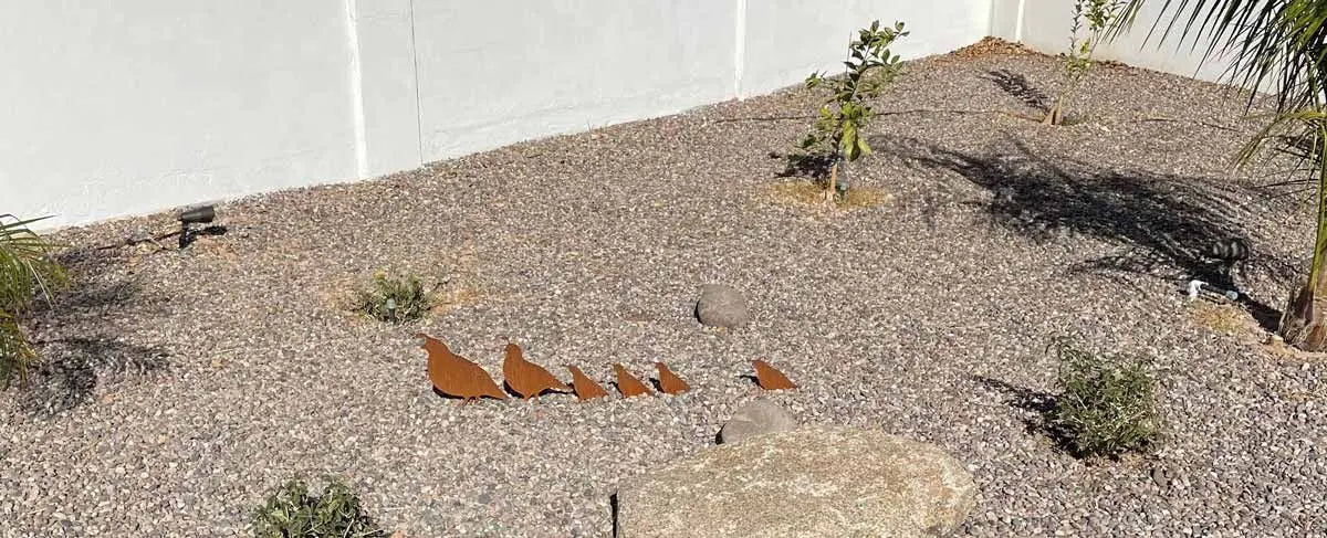metal quail displayed on the ground.