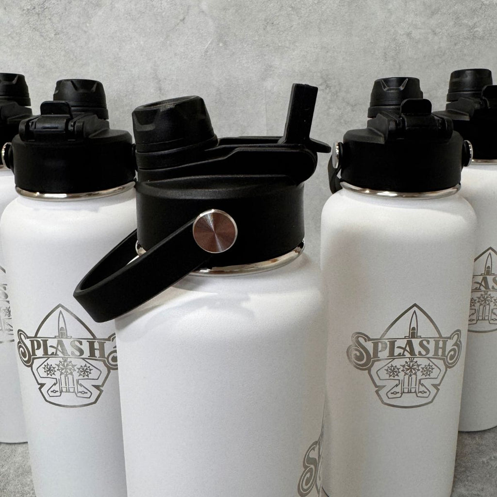White insulated water bottles with black lids and carry loops, arranged together on a gray surface. The front bottle shows an engraved Splash 3 logo.