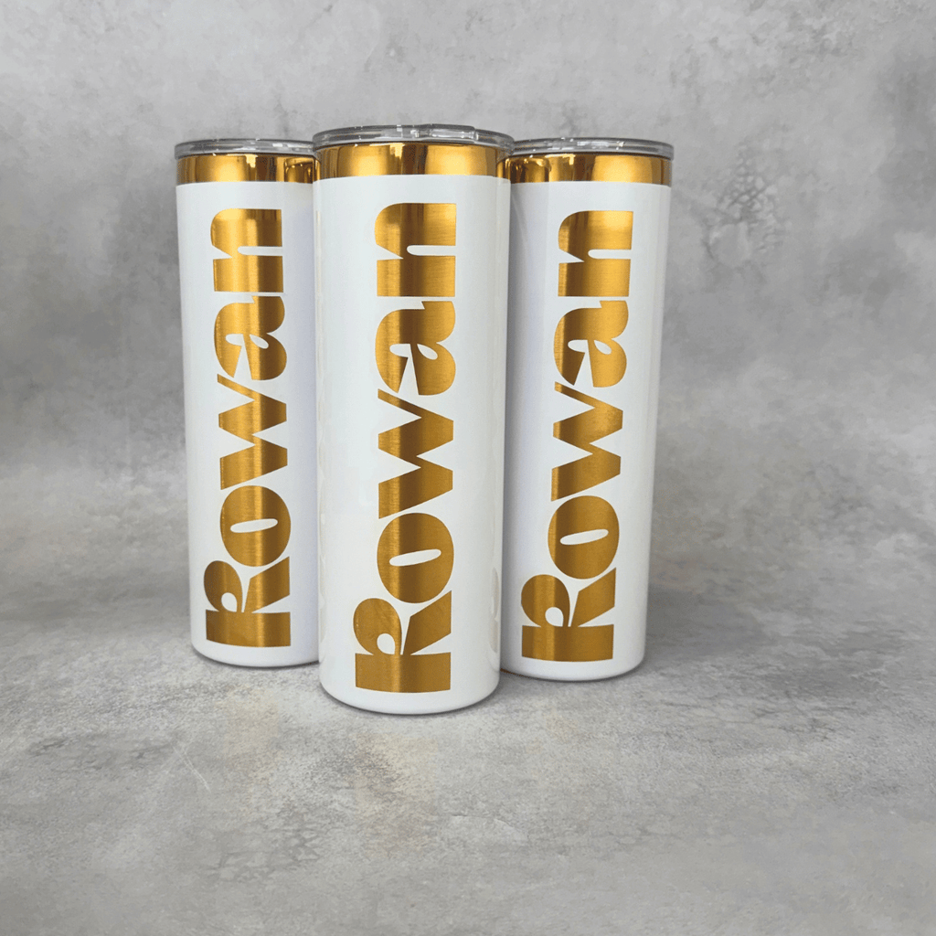 Skinny 20 oz tumbler laser engraved with custom branding, revealing a gold layer underneath