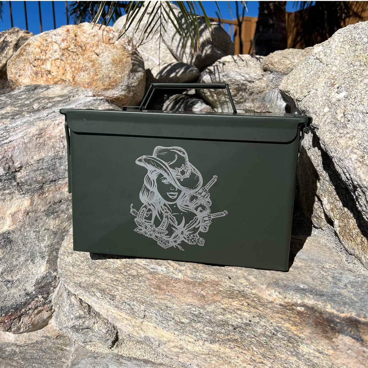 Laser engraved ammo can sitting on rocks.
