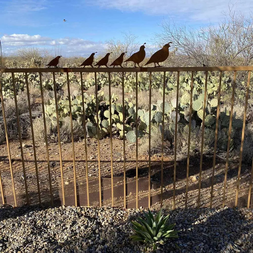metal quail family on a fence.