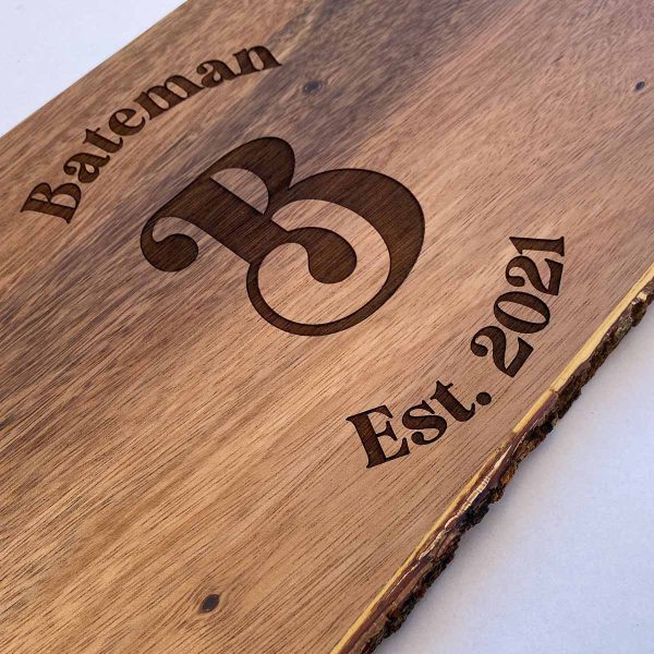 close up of personalized cutting board, says Bateman, Est. 2021 with large decorative B in middle