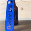 Beach life bottle opener in blue leaned against a bottle