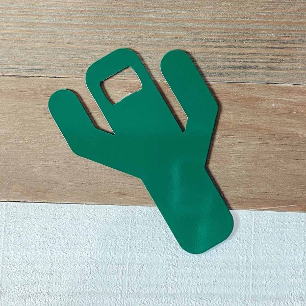 green metal cactus bottle opener on a shiplap background