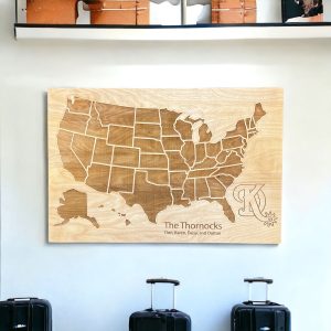 the top of three suitcases at the bottom of the picture, on the wall above is a personalized family travel map