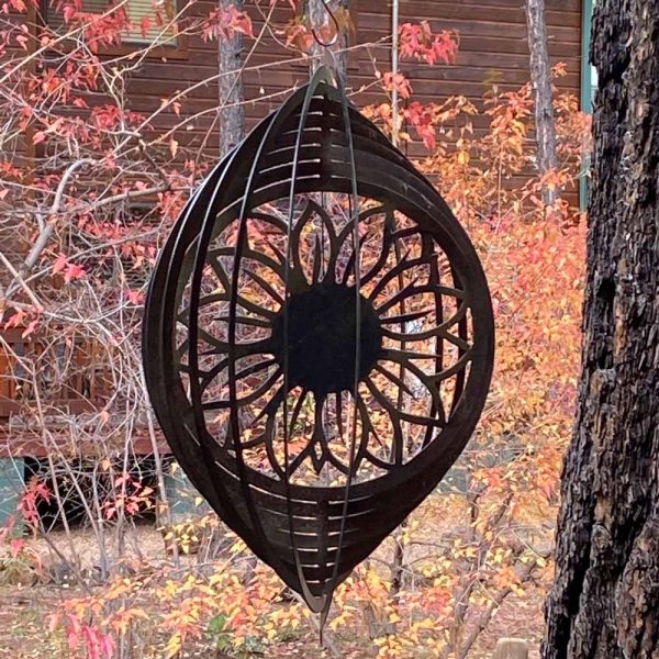 sunflower wind spinner in tree with fall leaves in the background