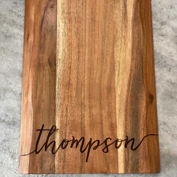 top down view of cutting board that is engraved with last name Thompson