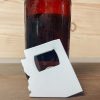 small white bottle opener in the state of arizona leaning against a bottle