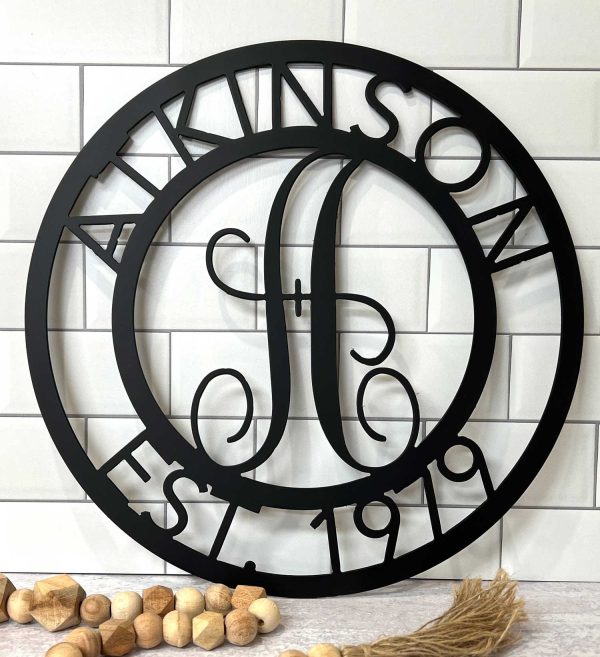metal monogram, black sign with a large A and the name Atkinson, Est 1979