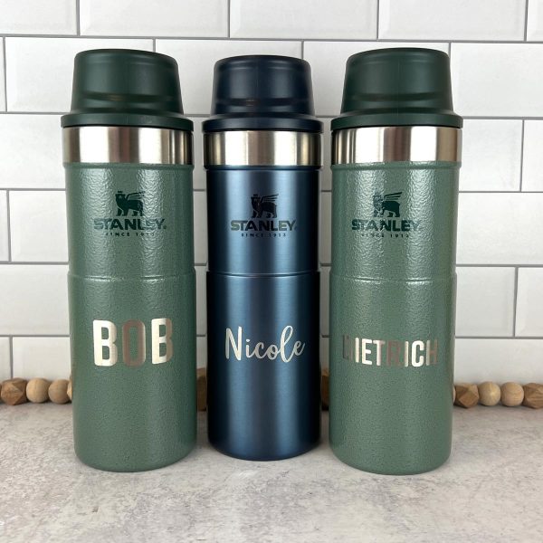 three Stanley brand thermos bottles, engraved with names